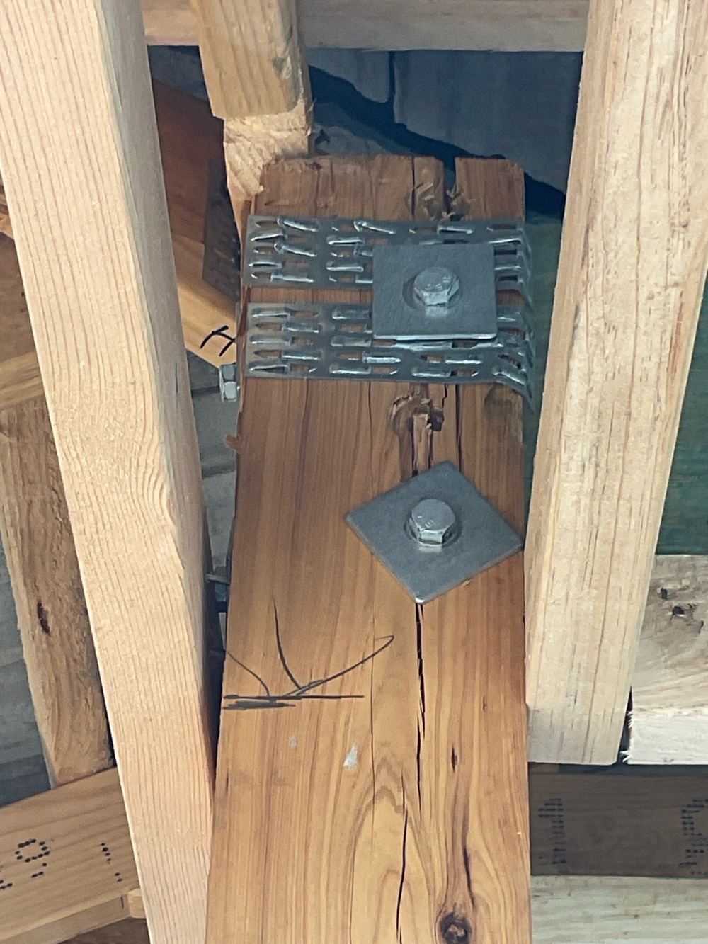 Split timber post with loose bolts at the beam, referred back to the engineer, found during a fixing inspection in Aintree