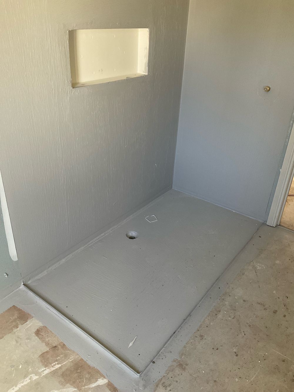 Membrane in the shower recess open to foot traffic and dropped tools, found during a waterproofing inspection in Sunshine West
